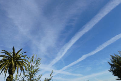photo of white streaks of contrails in the sky