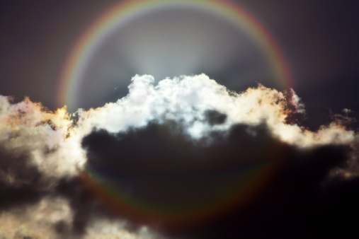 A circular rainbow as seen from a plane, with clouds in the center of the rainbow.