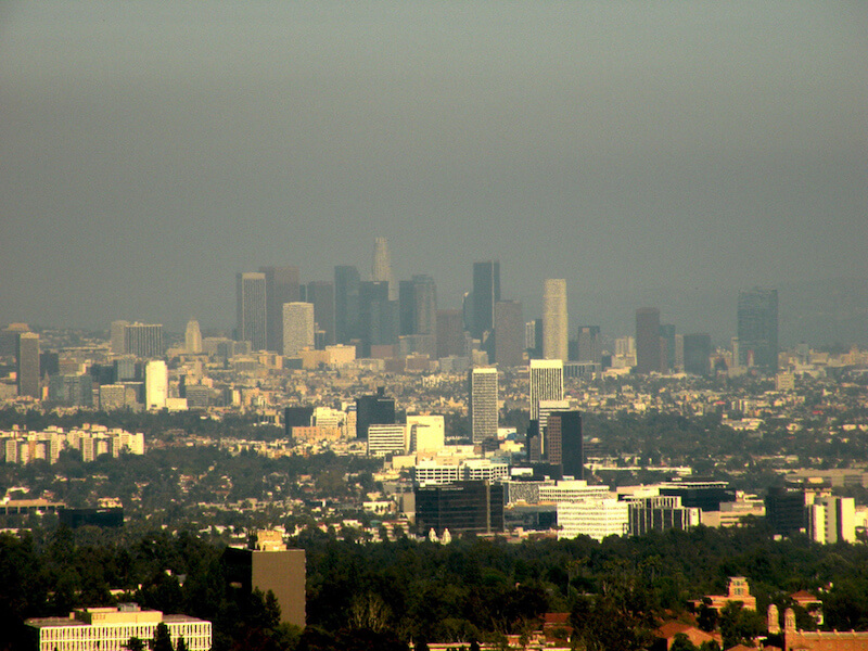 a photograph of a blue sky with smog in front of the skyscrapers of the Los Angeles skyline