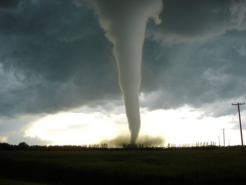 Image of a tornado touching down on the ground.