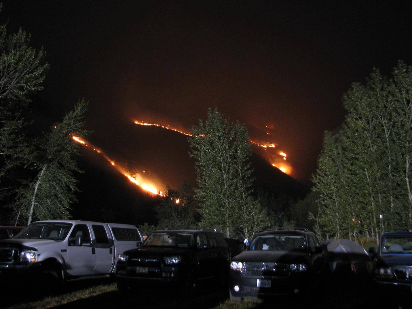 Photo of an incident command post near burning wild fire.