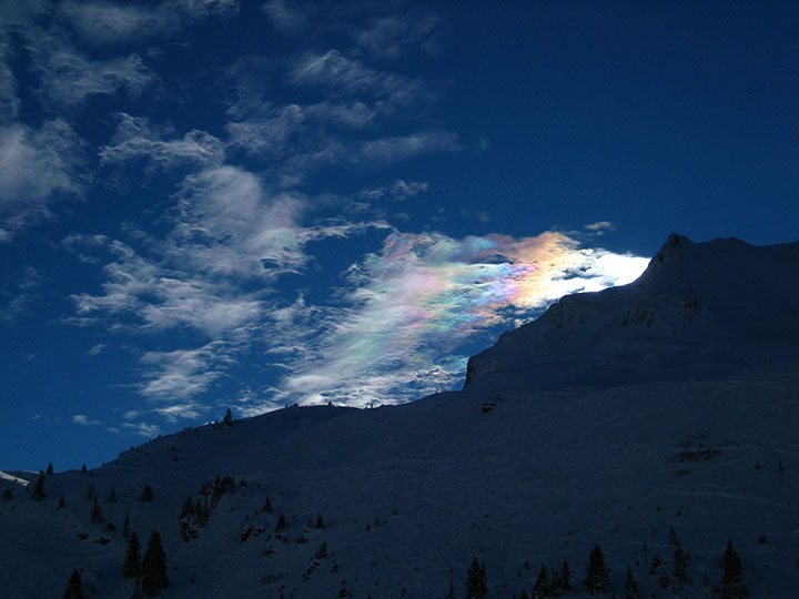 Bild einer Wolke, die Regenbogenfarben reflektiert