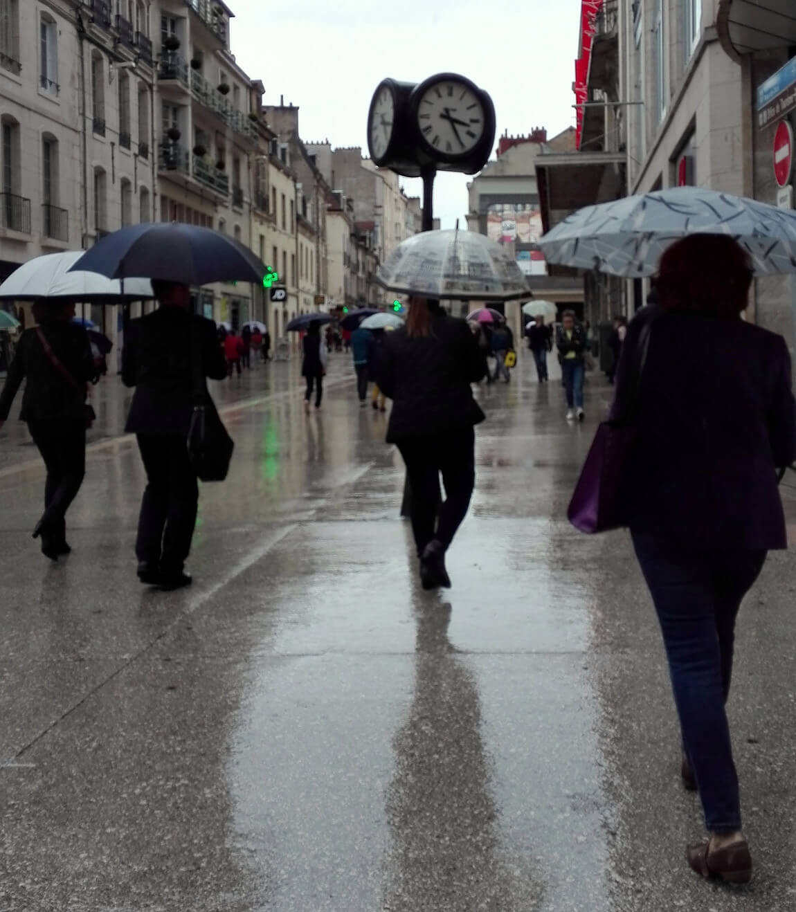 a photograph of people using umbrellas in the rain