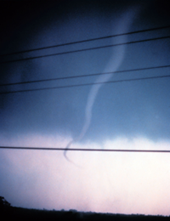 Photo of a funnel cloud hanging in the sky, not touching the ground.