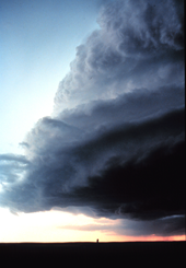 Photo of a large, dark, low-hanging cloud over half the sky, the rest of the sky clear.