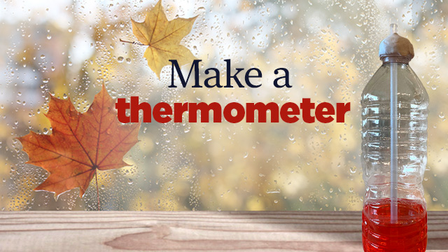 A plastic water bottle filled with red color water on a window sill.