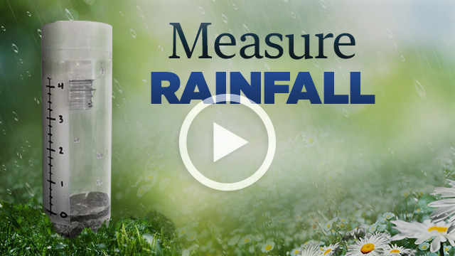 A cut-out plastic water bottle with rocks on grass