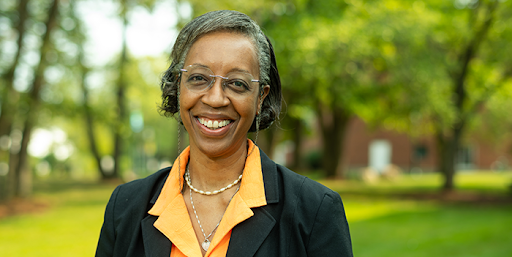 Lesley-Ann outside in a forest with the sun out.