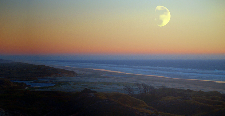 The ocean seen at dusk from a beach.