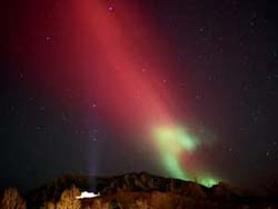 Night sky glowing with red and green light.